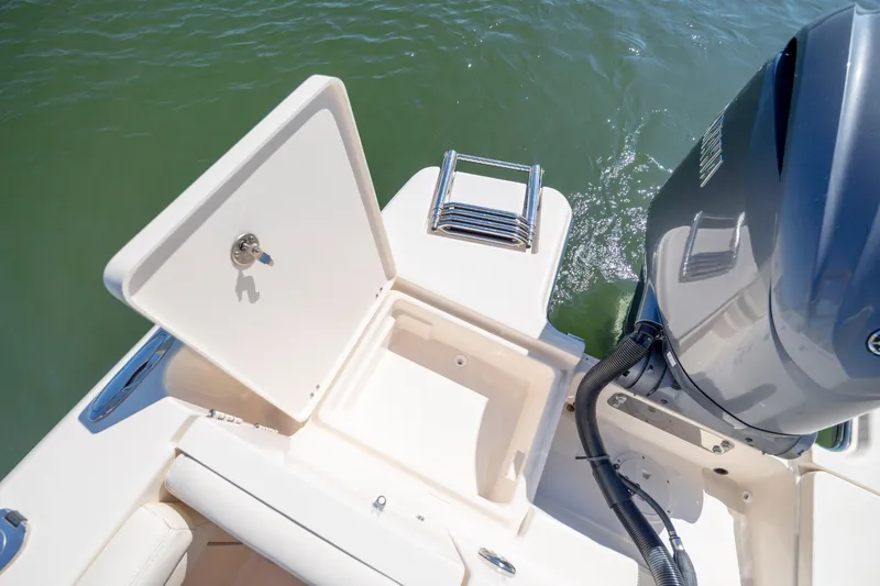 Slide: The Image of 2023 Grady-White Freedom 235 boat stern with open storage compartment and motor. - 26