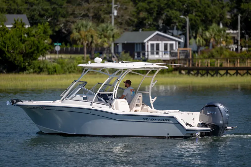 Slide: The Image of 2023 Grady-White Freedom 235 boat cruising on a serene waterway. - 3