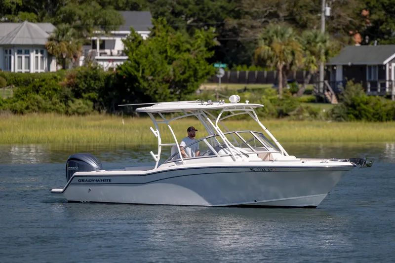 Slide: The Image of 2023 Grady-White Freedom 235 boat cruising on a calm waterway near lush greenery. - 5