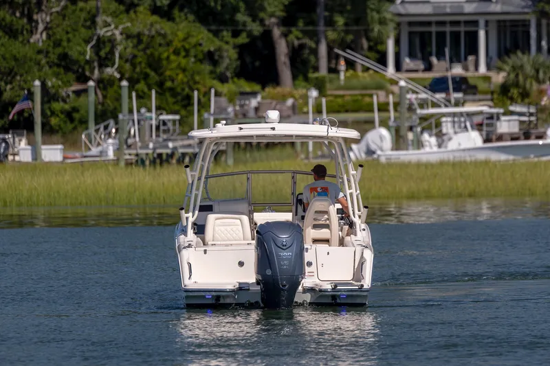 Slide: The Image of 2023 Grady-White Freedom 235 boat cruising on a serene waterway. - 8