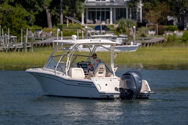 Slide: The Image of 2023 Grady-White Freedom 235 boat cruising on a calm lake near a dock. - 9