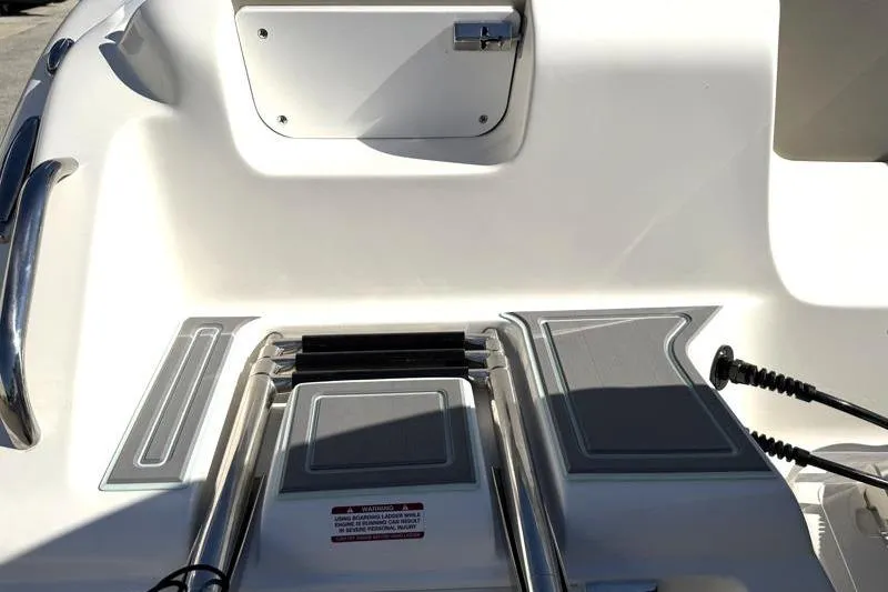 Slide: The Image of 2025 Key West 239 FS boat deck with stainless steel ladder and storage compartment. - 15