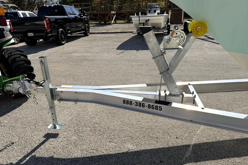 Slide: The Image of Boat trailer for 2025 Key West 239 FS, parked with vehicles in the background. - 53