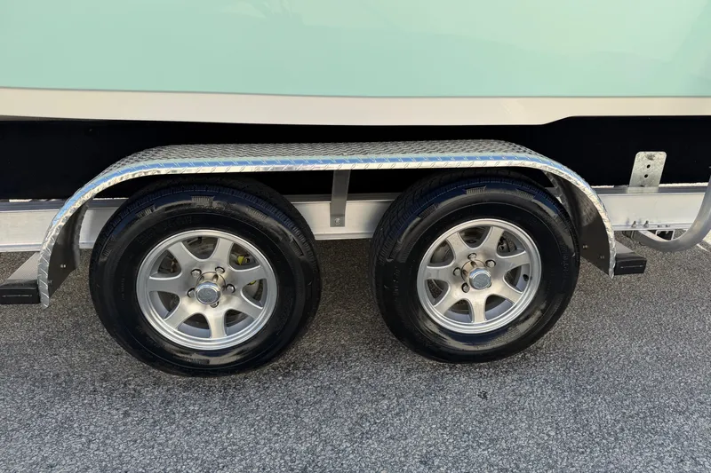 Slide: The Image of Trailer wheels of a 2025 Key West 239 FS boat on pavement. - 55