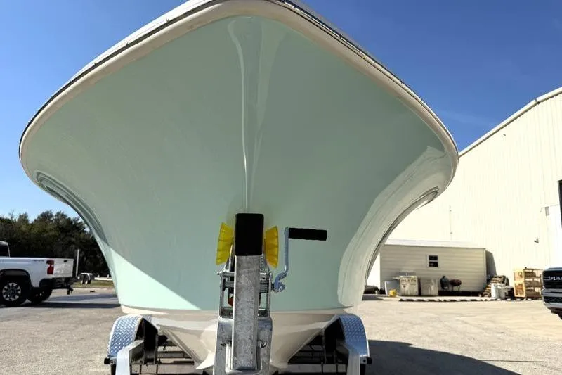 Slide: The Image of 2025 Key West 239 FS boat on trailer, parked outdoors under clear blue sky. - 8