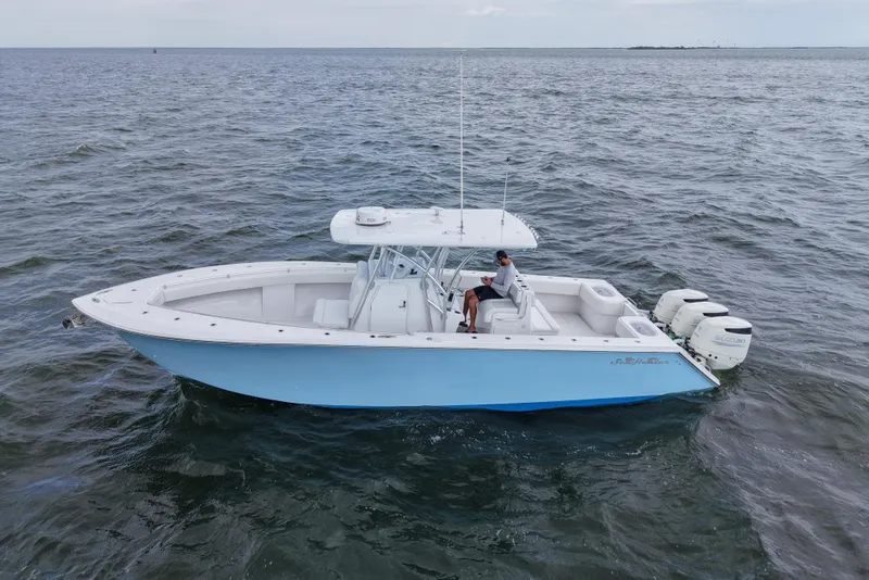 Slide: The Image of 2019 SeaHunter 33 Tournament boat on open water, featuring triple outboard engines. - 10