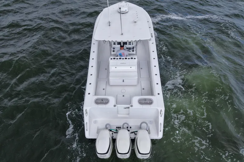 Slide: The Image of 2019 SeaHunter 33 Tournament boat on water, aerial view, triple engines visible. - 11