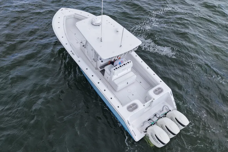 Slide: The Image of 2019 SeaHunter 33 Tournament boat on water, aerial view, triple engines. - 12
