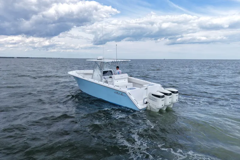 Slide: The Image of 2019 SeaHunter 33 Tournament boat cruising on open water under cloudy skies. - 2