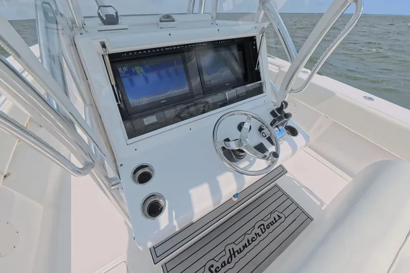 Slide: The Image of 2019 SeaHunter 33 Tournament boat console with steering wheel and navigation screens. - 22
