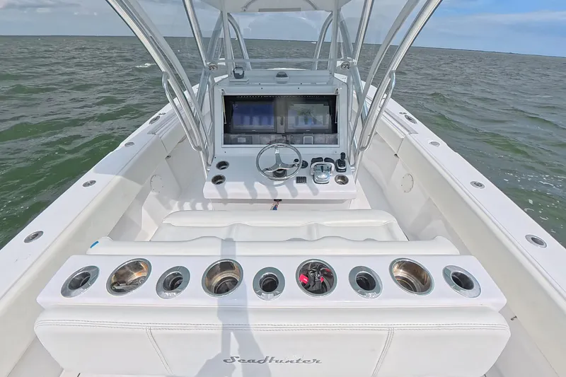 Slide: The Image of 2019 SeaHunter 33 Tournament boat cockpit with steering wheel and control panel on open water. - 26