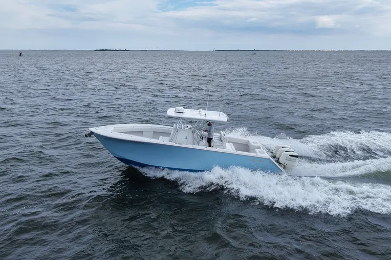 Slide: The Image of 2019 SeaHunter 33 Tournament boat cruising on open water under a cloudy sky. - 37