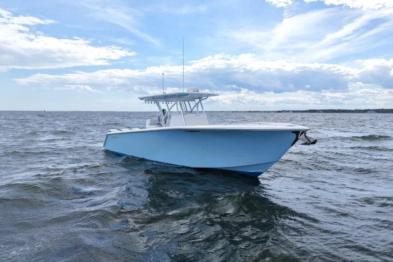 Slide: The Image of 2019 SeaHunter 33 Tournament boat on open water under a partly cloudy sky. - 6