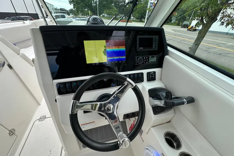 Slide: The Image of 2021 Sailfish 276 DC boat dashboard with steering wheel and navigation display. - 10