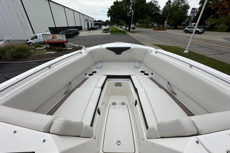 Slide: The Image of 2021 Sailfish 276 DC boat interior with spacious seating and storage at a marina. - 11