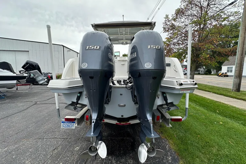 Slide: The Image of 2021 Sailfish 276 DC boat with dual Yamaha 150 engines, parked outdoors. - 15