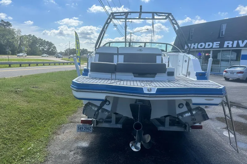 Slide: The Image of 2020 Monterey M4 boat with dual propellers, parked near a road under a clear blue sky. - 1
