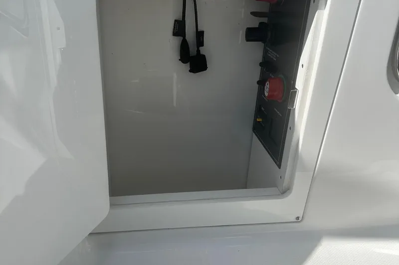 Slide: The Image of Open compartment on a 2020 Monterey M4 boat, showing control panel and switches. - 21