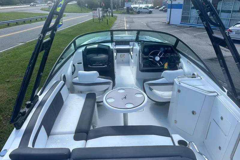 Slide: The Image of 2020 Monterey M4 boat interior with seating, steering wheel, and table on a sunny day. - 25