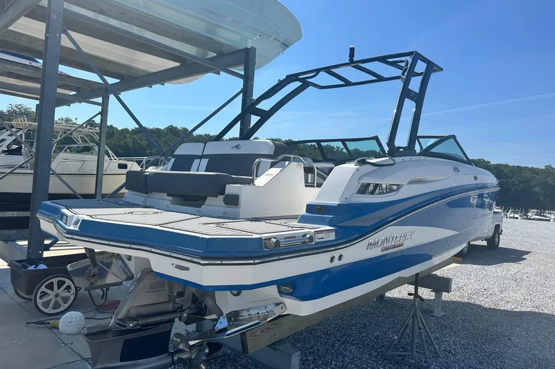 Slide: The Image of 2020 Monterey M4 boat in blue and white on a trailer at a marina. - 4