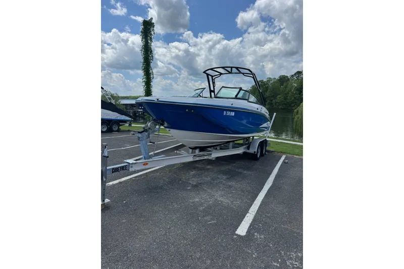 Slide: The Image of 2020 Monterey M4 boat on trailer, parked near a lake under a cloudy sky. - 7