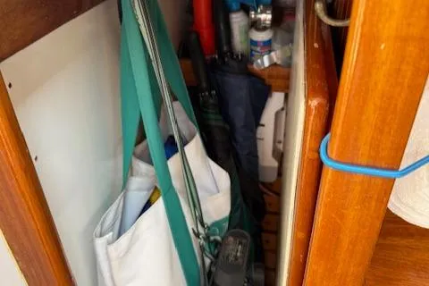 Slide: The Image of Storage area on a 2005 Custom Gannon & Benjamin boat with various items and wooden interior. - 19