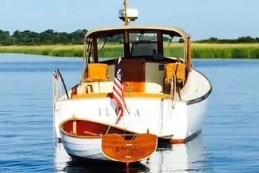 Slide: The Image of Custom Gannon & Benjamin 2005 boat with American flag on calm water. - 2