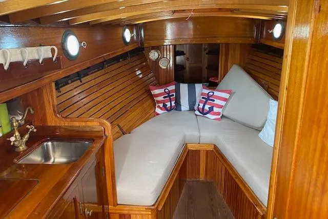 Slide: The Image of Cozy wooden boat interior with cushioned seating, nautical decor, and a small sink. Custom Gannon & Benjamin, 2005. - 21