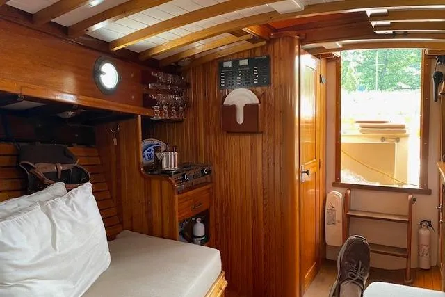 Slide: The Image of Interior of a 2005 Custom Gannon & Benjamin boat with wooden finishes and cozy seating. - 23