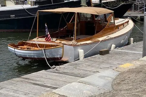 Slide: The Image of Custom 2005 Gannon & Benjamin boat docked, featuring wooden design and American flag. - 4