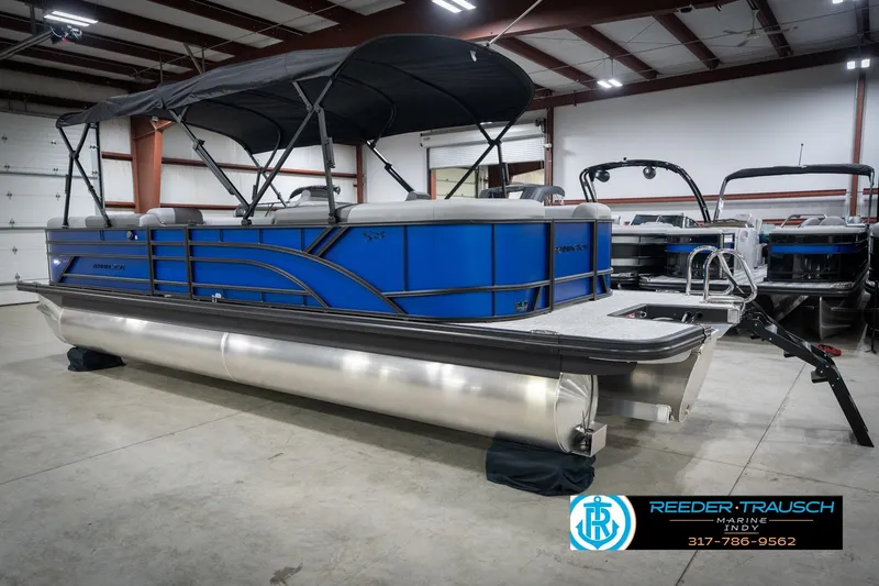 Slide: The Image of 2026 Bennington 25 SSR pontoon boat in showroom, featuring sleek blue design and canopy. - 10