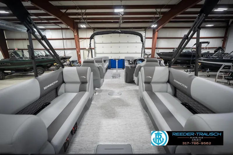 Slide: The Image of 2026 Bennington 25 SSR pontoon boat interior in showroom, featuring spacious seating and modern design. - 19
