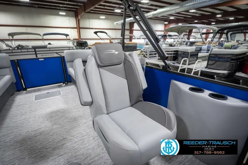 Slide: The Image of 2026 Bennington 25 SSR boat interior with gray seating in a showroom. - 26