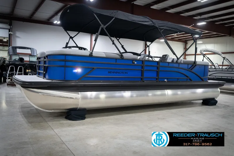 Slide: The Image of 2026 Bennington 25 SSR pontoon boat in showroom, blue exterior, black canopy. - 4