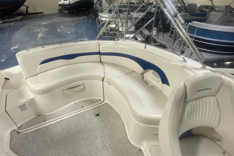 Slide: The Image of 2002 Chaparral Sunesta 243 boat interior with white and blue seating in showroom. - 3