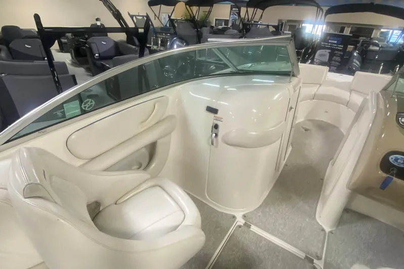 Slide: The Image of 2002 Chaparral Sunesta 243 boat interior with white seating and helm area. - 5