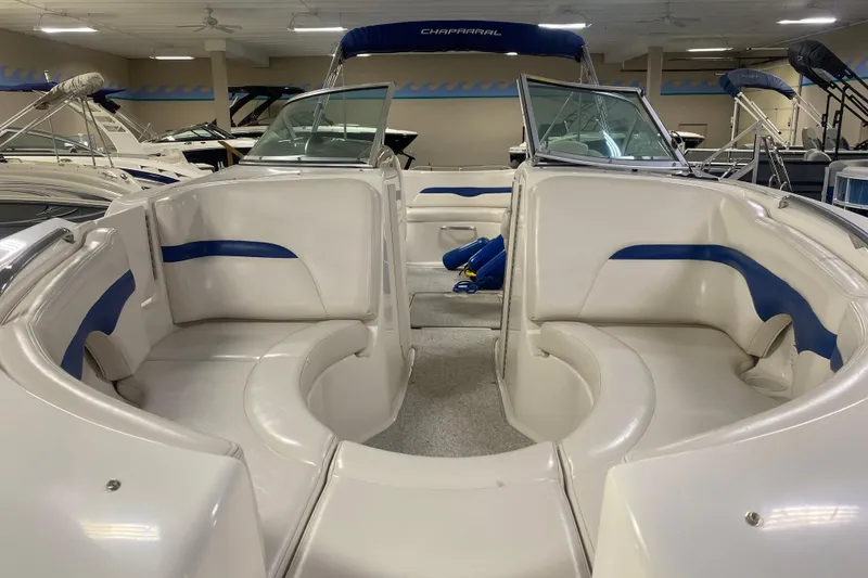 Slide: The Image of 2002 Chaparral Sunesta 243 boat interior with white and blue seating in showroom. - 7