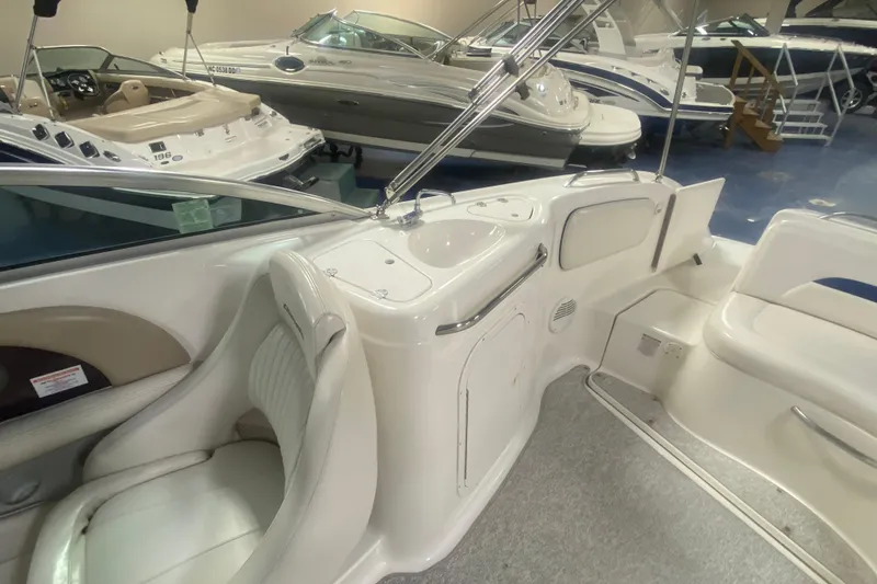 Slide: The Image of 2002 Chaparral Sunesta 243 interior with seating and sink, displayed in a showroom. - 8