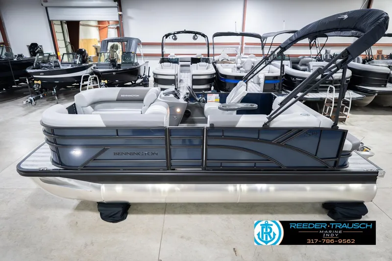 The Image of 2026 Bennington 188 SLJ pontoon boat displayed in a showroom with other boats. - 0