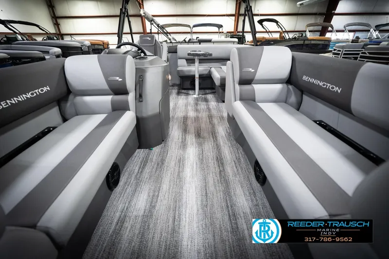 Slide: The Image of 2026 Bennington 188 SLJ boat interior with gray seating and steering console in showroom. - 16