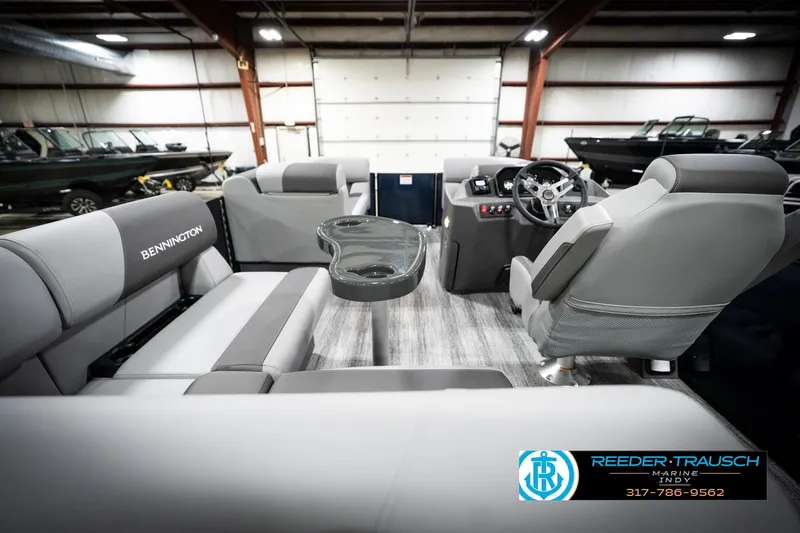 Slide: The Image of 2026 Bennington 188 SLJ pontoon boat interior in showroom, featuring gray seating and carpet. - 18