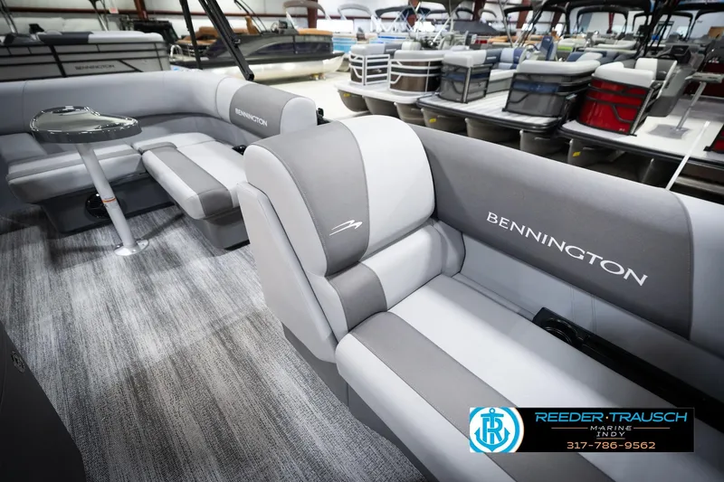 Slide: The Image of 2026 Bennington 188 SLJ pontoon boat interior with gray seating and table in showroom. - 21