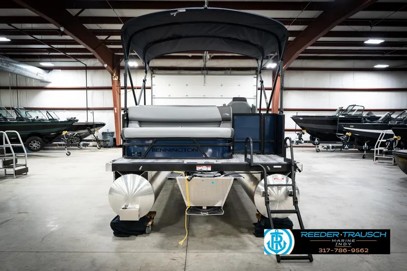 Slide: The Image of 2026 Bennington 188 SLJ pontoon boat in showroom with canopy and sleek design. - 9