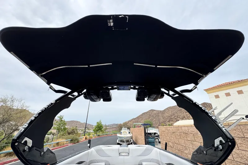 Slide: The Image of 2015 Centurion Enzo FS44 boat with black canopy, parked near mountains. - 18