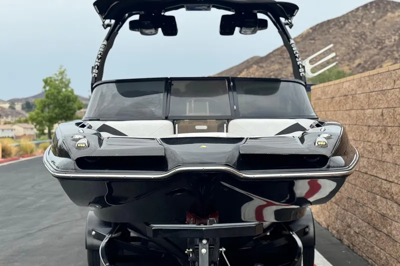 Slide: The Image of 2015 Centurion Enzo FS44 boat, black exterior, parked on a paved road. - 2