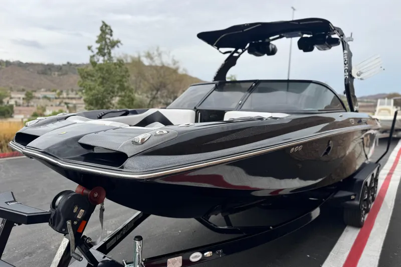 Slide: The Image of 2015 Centurion Enzo FS44 boat on trailer, sleek black design, parked outdoors. - 3