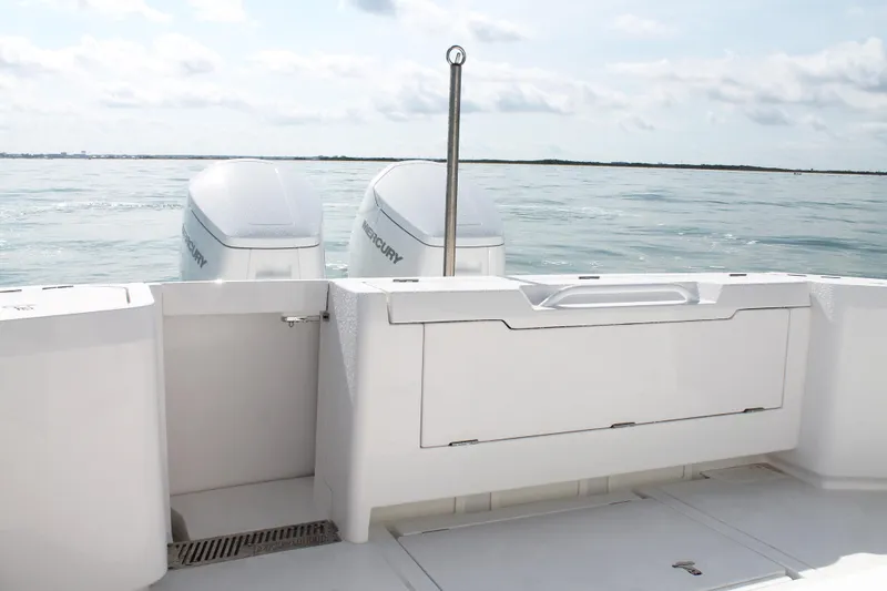 Slide: The Image of 2024 Intrepid 41 Valor boat stern with twin Mercury engines on calm water. - 13