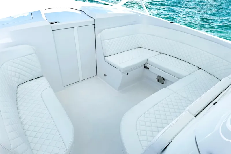 Slide: The Image of Luxurious white seating on 2024 Intrepid 41 Valor boat, with quilted upholstery and ocean backdrop. - 27