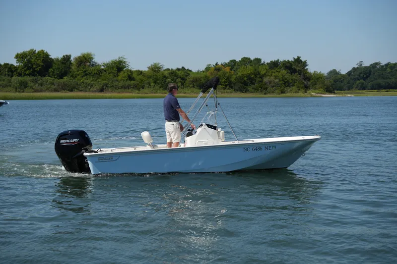 Slide: The Image of 2025 Boston Whaler 170 Montauk boat cruising on a serene lake. - 1
