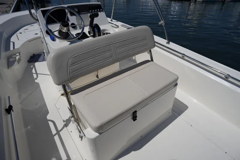 Slide: The Image of 2025 Boston Whaler 170 Montauk boat interior with steering console and cushioned seating. - 12